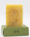 Yellow soap bar with 'Komoni' imprinted branding on a white background