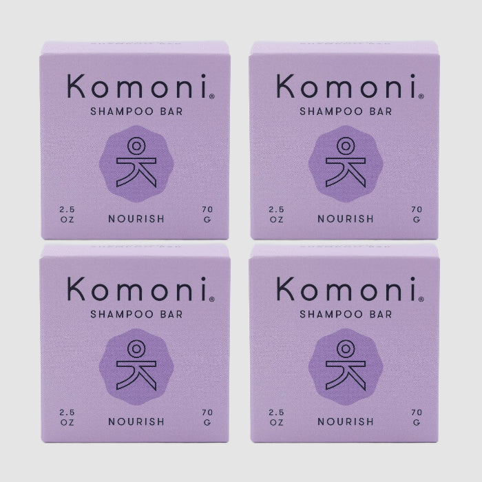 Four lavender colored boxes of Komoni eco-friendly, concentrated NOURISH Essential Oil Shampoo bars shown in a grid.