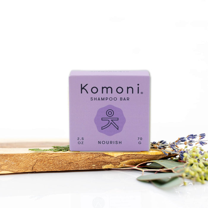 NOURISH concentrated eco-friendly essential oil shampoo bar shown in pastel purple box.