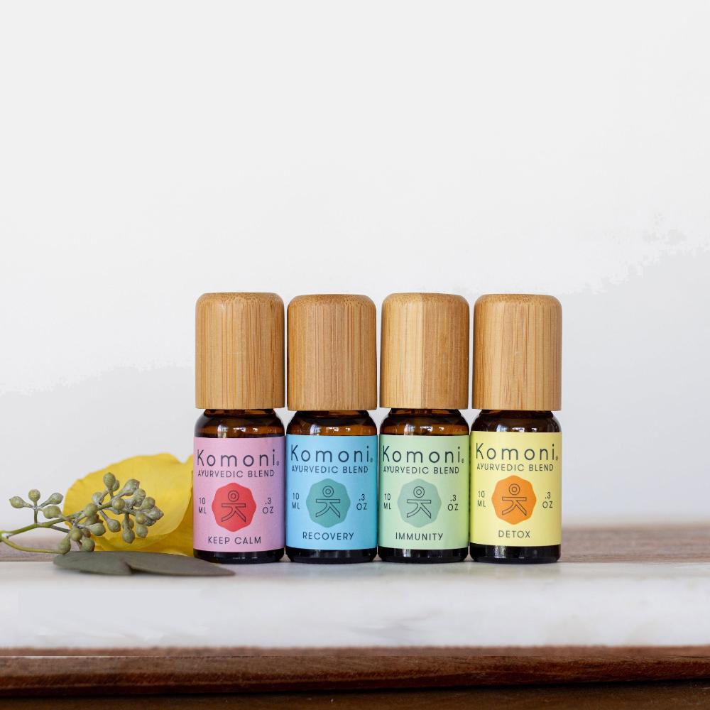10 mL vials with wood tops of each of the 4 Pure Essential Oil Ayurvedic Blends.