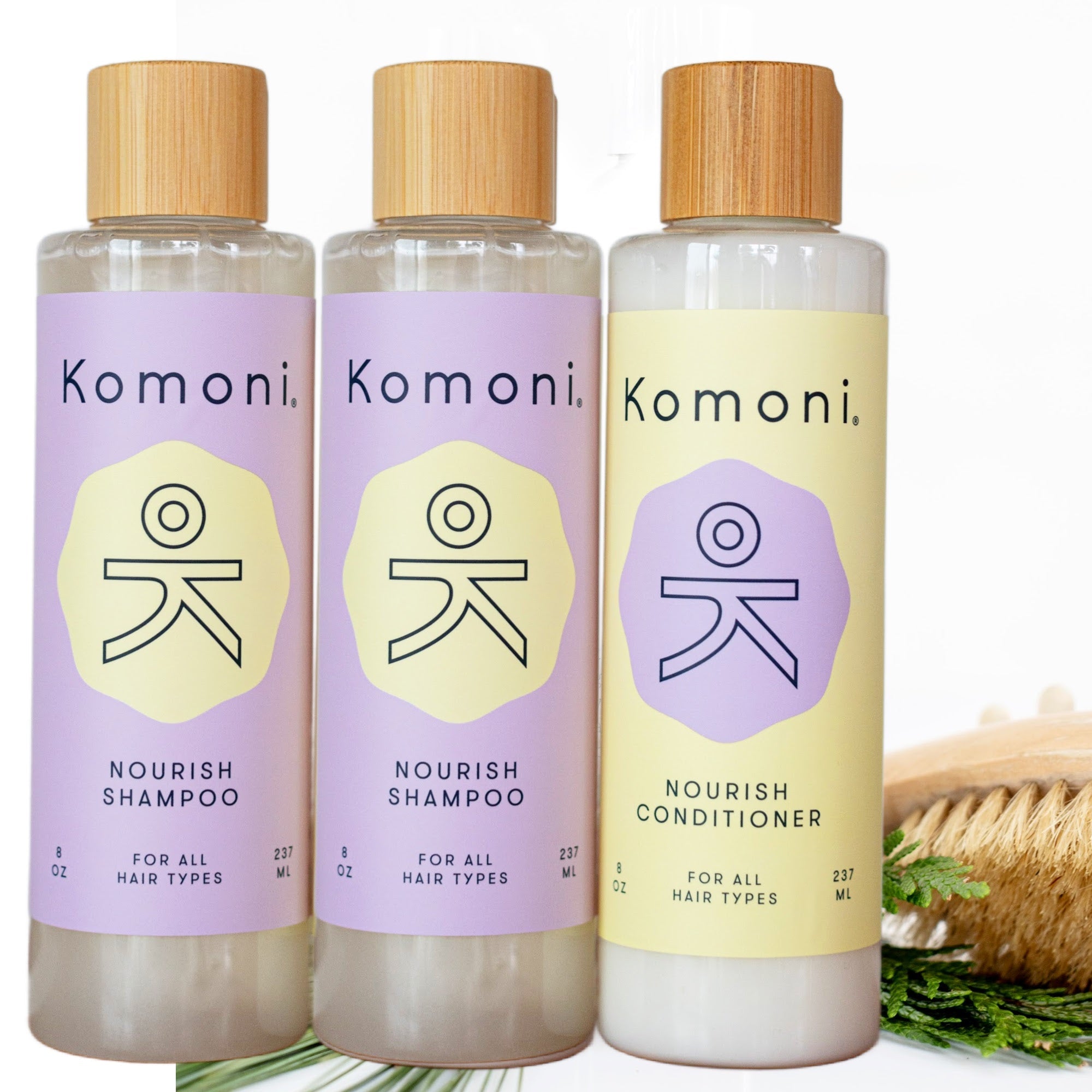 A woman in a bath towel dispensing all-natural botanical shampoo or conditioner with essential oils into her hand from an 8 oz bottle with elegant bamboo top.